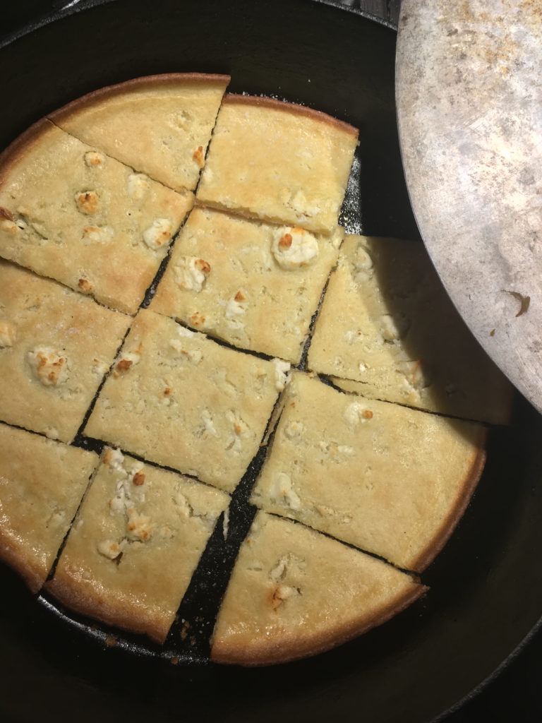 Alevropita cut into squares in a cast-iron skillet